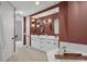 Bright bathroom featuring double vanity, modern fixtures, soaking tub, and round mirrors at 5238 Manorwood Dr # 3C, Sarasota, FL 34235