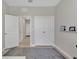 Neutral bedroom with a gray rug and convenient closet and hallway access at 5715 Woodland Sage Dr, Sarasota, FL 34238