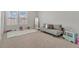 Bright bedroom with a gray sofa, carpet, and large windows at 5715 Woodland Sage Dr, Sarasota, FL 34238