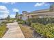 Inviting clubhouse exterior with covered patio, manicured hedges, and sidewalk access at 5715 Woodland Sage Dr, Sarasota, FL 34238