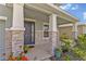 Close up of a covered front porch, showing stone wrapped columns and an inviting front door at 5715 Woodland Sage Dr, Sarasota, FL 34238