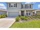 Charming two-story home featuring stone accents, a two-car garage, and a well-manicured front yard at 5715 Woodland Sage Dr, Sarasota, FL 34238