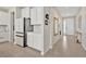 Hallway shows tile flooring and entrance to the kitchen with a large refrigerator at 5715 Woodland Sage Dr, Sarasota, FL 34238