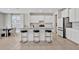 Kitchen with white cabinets, marble countertops, and black/gold counter stools at 5715 Woodland Sage Dr, Sarasota, FL 34238