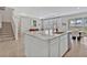 Bright open concept kitchen with marble countertops, stainless steel sink, and stairs at 5715 Woodland Sage Dr, Sarasota, FL 34238