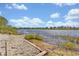 Picturesque view of the lake shore featuring a rocky shoreline and clear water at 5715 Woodland Sage Dr, Sarasota, FL 34238