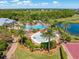 Aerial view of the community pools, splashpad, and recreational amenities, nestled among lush landscaping and a pond at 5749 Sunflower Cir, Sarasota, FL 34238