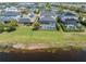 An aerial view of homes featuring backyard pools with screened enclosures along a pond at 5749 Sunflower Cir, Sarasota, FL 34238