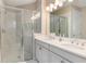 Modern bathroom featuring a glass shower, double sink vanity, and white marble tiling at 5749 Sunflower Cir, Sarasota, FL 34238