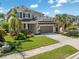 Attractive two-story home with well-maintained lawn, mature palm trees, and a two-car garage at 5749 Sunflower Cir, Sarasota, FL 34238