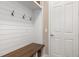 Mudroom featuring a wooden bench with storage, complemented by white shiplap walls and coat hooks for added functionality at 5749 Sunflower Cir, Sarasota, FL 34238