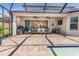 Spacious, covered patio featuring an outdoor kitchen area and a dining set, perfect for entertaining by the pool at 5749 Sunflower Cir, Sarasota, FL 34238