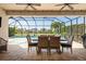 Inviting covered patio with a dining set, overlooking the pool and landscaping through a screened enclosure at 5749 Sunflower Cir, Sarasota, FL 34238