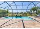 Screened in pool with brick paver deck surrounded by lush landscaping and serene views at 5749 Sunflower Cir, Sarasota, FL 34238