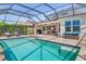 A backyard pool with a screened enclosure, brick paver deck, seating and an outdoor dining area at 5749 Sunflower Cir, Sarasota, FL 34238