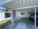 A carport view highlighting the shared structure, adjacent home with shuttered window, and parked vehicles at 6072 Arlene Way # 6072, Bradenton, FL 34207