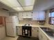 Well-lit kitchen featuring white cabinets and classic appliances at 6072 Arlene Way # 6072, Bradenton, FL 34207