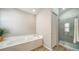 Bright bathroom with tub, glass shower, and wood-look flooring at 6128 Nicole Dr, Sarasota, FL 34243