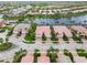 High aerial of a lakeside community, featuring tile roofs, mature landscaping, and serene water views at 6209 Erice St, Venice, FL 34293