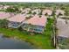 Relaxing lakeside home featuring a private screened-in pool, lush backyard, and tropical landscaping at 6209 Erice St, Venice, FL 34293