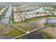 An aerial view of houses next to a waterway with a nature preserve with walking bridge and gazebo at 6209 Erice St, Venice, FL 34293