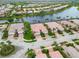 High aerial view of a lake community, featuring tile roofs, mature landscaping, and scenic water views at 6209 Erice St, Venice, FL 34293