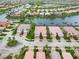 Aerial view of homes with tile roofs, brick driveways, attached garages, and manicured lawns at 6209 Erice St, Venice, FL 34293