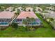 An aerial view of a tile-roofed home featuring a screened-in pool and lush, green landscaping in a tropical neighborhood at 6209 Erice St, Venice, FL 34293