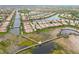 An aerial view of houses next to a waterway with a nature preserve with walking bridge and gazebo at 6209 Erice St, Venice, FL 34293