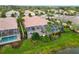 Aerial shot of screened-in pool with view of lush backyard landscaping and canal at 6209 Erice St, Venice, FL 34293