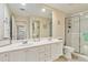 Bright bathroom features dual vanity with white cabinets and walk-in glass shower at 6209 Erice St, Venice, FL 34293