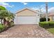 A home featuring a brick driveway leading to an attached two car garage with carriage doors and landscaped curb appeal at 6209 Erice St, Venice, FL 34293