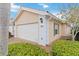 A close exterior shot of the garage featuring carriage doors and well maintained landscaping at 6209 Erice St, Venice, FL 34293