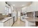 Bright kitchen features white cabinetry, tile backsplash, and modern appliances, offering a clean and functional space at 6209 Erice St, Venice, FL 34293