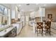 Bright kitchen featuring white cabinets, a breakfast bar, and views out a window at 6209 Erice St, Venice, FL 34293