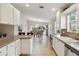 An eat-in kitchen boasts white cabinets and views to the dining and backyard areas at 6209 Erice St, Venice, FL 34293