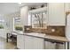 Kitchen features a double sink, stainless steel dishwasher, ample counter space, and sunlit windows with a view at 6209 Erice St, Venice, FL 34293