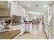 Bright kitchen featuring white cabinets, light countertops, tiled floors, and a breakfast nook in the background at 6209 Erice St, Venice, FL 34293