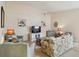 A bright living room with neutral walls, a ceiling fan, comfortable seating, and tiled floors at 6209 Erice St, Venice, FL 34293