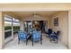 Outdoor patio with comfortable blue seating and a ceiling fan, seamlessly connects indoor dining at 6209 Erice St, Venice, FL 34293