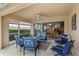 Outdoor patio with comfortable blue seating and a ceiling fan, seamlessly connects indoor dining at 6209 Erice St, Venice, FL 34293