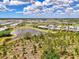Scenic aerial shot of the community, featuring numerous homes surrounding a tranquil lake and natural landscape at 6267 Crested Eagle Ln, Nokomis, FL 34275