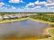 Expansive aerial view of a residential community featuring a large pond and beautifully landscaped homes at 6267 Crested Eagle Ln, Nokomis, FL 34275