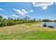 Expansive green backyard leading to a serene pond, creating a peaceful and natural setting at 6267 Crested Eagle Ln, Nokomis, FL 34275