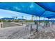 Picturesque bocce ball court under a shaded canopy with seating, and tropical landscaping at 6267 Crested Eagle Ln, Nokomis, FL 34275