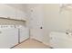 Well-lit laundry room with washer, dryer, utility sink, and storage cabinets at 6267 Crested Eagle Ln, Nokomis, FL 34275