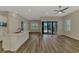 Open living area with a kitchen island, hardwood floors, and glass sliding doors to the outdoor space at 6267 Crested Eagle Ln, Nokomis, FL 34275