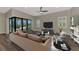 Cozy living room featuring hardwood floors, neutral colors, and sliding glass doors to the pool area at 6267 Crested Eagle Ln, Nokomis, FL 34275