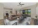 Bright and airy living room open to kitchen features modern decor and sliding glass doors to the pool at 6267 Crested Eagle Ln, Nokomis, FL 34275