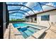Beautiful screened-in pool and hot tub combination with travertine tile and clear blue skies overhead at 6267 Crested Eagle Ln, Nokomis, FL 34275